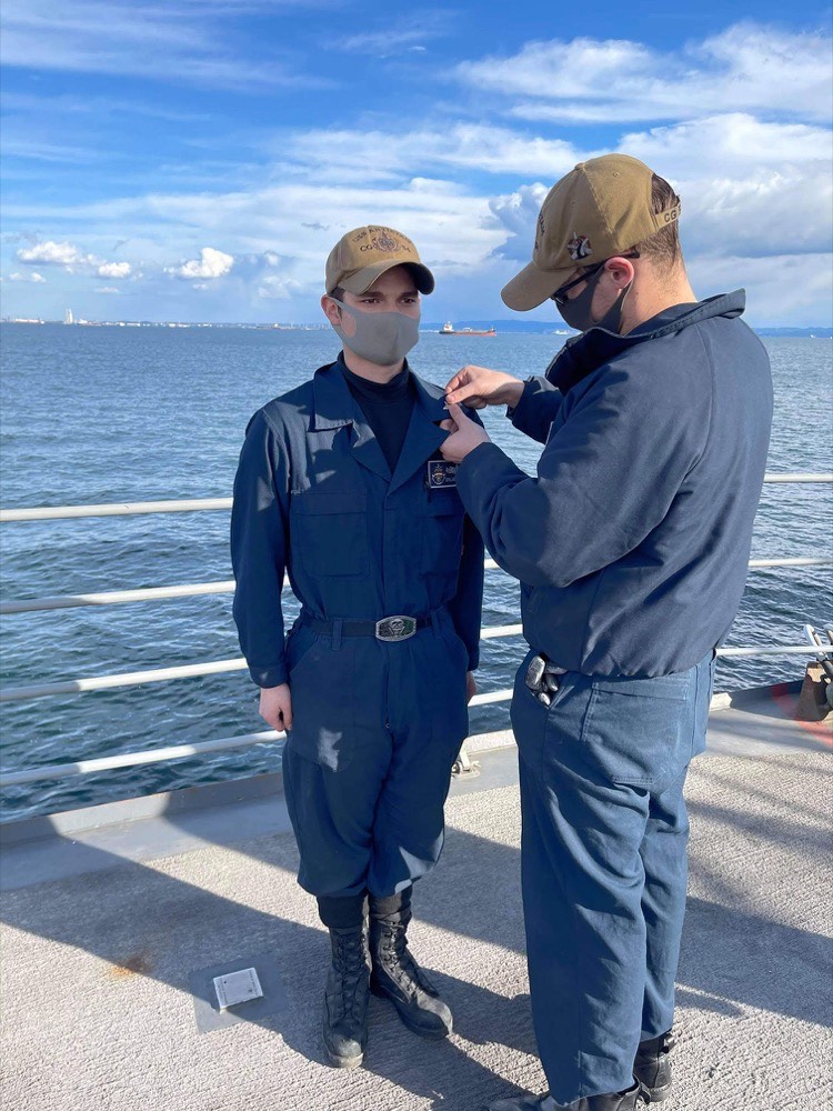 Dylan Little receiving a qualification pin aboard USS Antietam